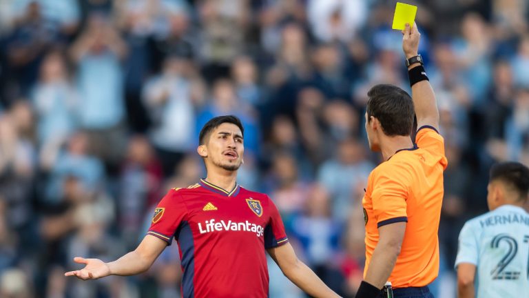 Real Salt Lake midfielder Pablo Ruiz (6) is shown a yellow card by referee Joe Dickerson during the first half of the team's MLS soccer match against Sporting Kansas City on Saturday, March 26, 2022, in Kansas City, Kan. (Nick Tre. Smith/AP)