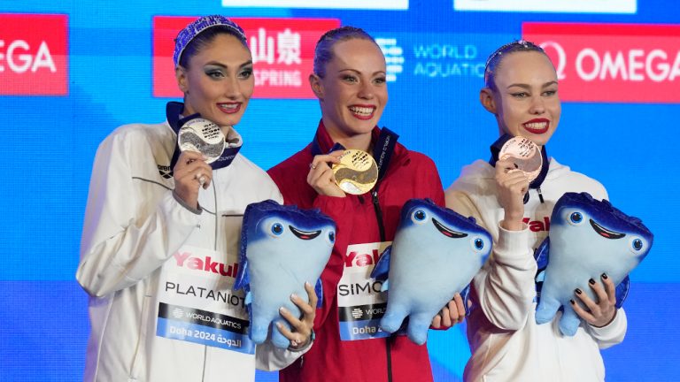 Gold medalist Jacqueline Simoneau of Canada, center, silver medalist Evangelia Platanioti, of Greece, and bronze medalist Vasilina Khandoshka, a competitor from Belarus, pose for a photo during the medal ceremony for the women's solo free final of artistic swimming at the World Aquatics Championships in Doha, Qatar, Tuesday, Feb. 6, 2024. (Lee Jin-man/CP)