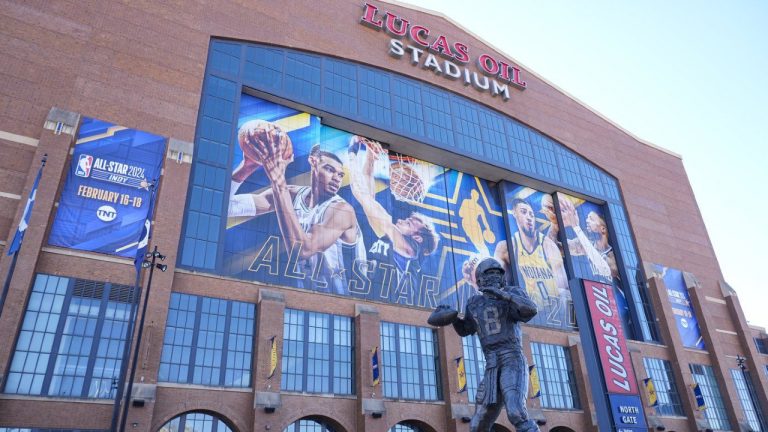 A statue of Indianapolis Colts quarterback Peyton Manning stand in front of signage promoting the NBA All-Star basketball game on the window on Lucas Oil Stadium in Indianapolis, Wednesday, Feb. 14, 2024. (Michael Conroy/AP)