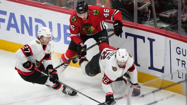 Chicago Blackhawks' Louis Crevier (46) checks Ottawa Senators' Mark Kastelic (12) to the ice as Parker Kelly watches during the first period of an NHL hockey game Saturday, Feb. 17, 2024, in Chicago. (Charles Rex Arbogast/AP)