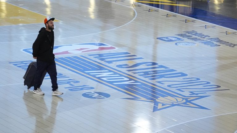 Travellers using Indianapolis International Airport make their way across a replica of the court that will be use for the NBA All-Star game Thursday, Jan. 18, 2024. (Michael Conroy/AP)