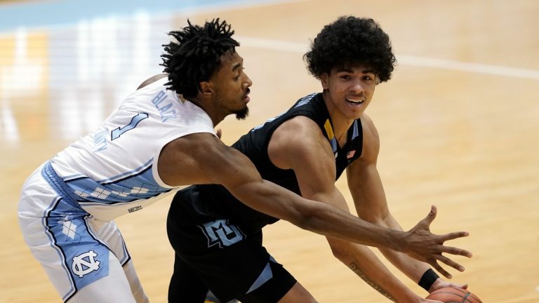 North Carolina guard Leaky Black (1) guards Marquette guard D.J. Carton during the second half of an NCAA college basketball game in Chapel Hill, N.C., Wednesday, Feb. 24, 2021. (Gerry Broome/AP Photo)