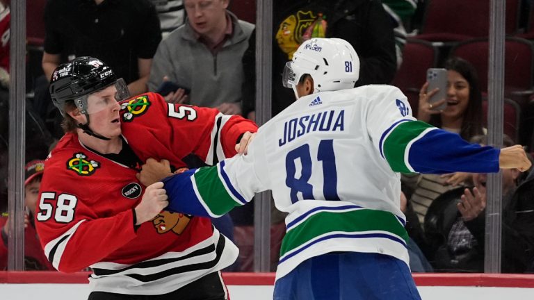 Chicago Blackhawks right wing MacKenzie Entwistle, left, and Vancouver Canucks center Dakota Joshua fight during the third period of an NHL hockey game, Tuesday, Feb. 13, 2024, in Chicago. The Canucks won 4-2. (Erin Hooley/AP)