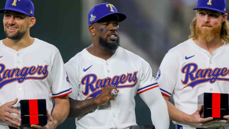 Texas Rangers players Nathan Eovaldi, left; Adolis Garcia, center; and Jon Gray, right, pose with their World Series rings before a baseball game against the Chicago Cubs, Saturday, March 30, 2024, in Arlington, Texas. (Gareth Patterson/AP)