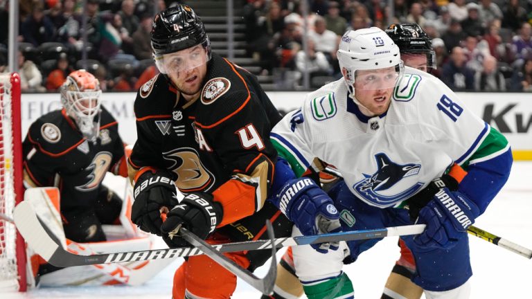 Anaheim Ducks defenceman Cam Fowler, centre, battles with Vancouver Canucks centre Sam Lafferty during the second period of an NHL hockey game Sunday, March 3, 2024, in Anaheim, Calif. (AP Photo/Mark J. Terrill)
