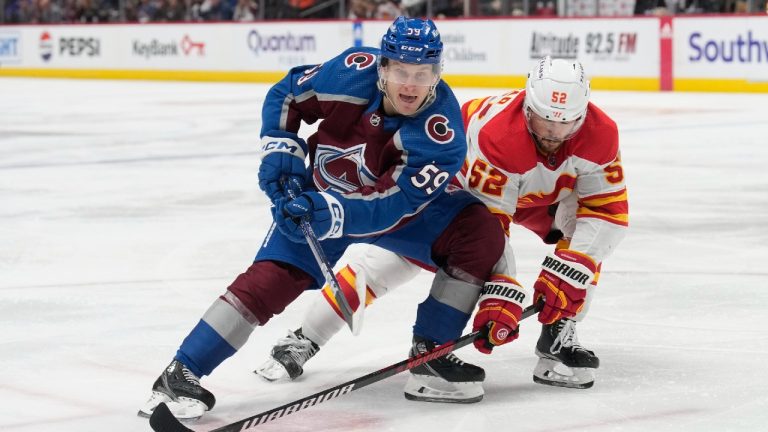 Colorado Avalanche forward Ben Meyers, left, and Calgary Flames defenseman MacKenzie Weegar (52) in the third period of an NHL hockey game Monday, Dec. 11, 2023, in Denver. (David Zalubowski/AP)