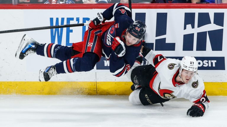Winnipeg Jets' Josh Morrissey (44) and Ottawa Senators' Parker Kelly (27) collide during first period NHL action in Winnipeg on Saturday, March 30, 2024. (John Woods/CP)