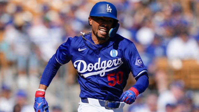 Los Angeles Dodgers' Mookie Betts runs to first base after hitting a single in the fifth inning of a spring training baseball game against the Texas Rangers on Saturday, March 9, 2024, in Phoenix. (AP Photo/Carolyn Kaster)