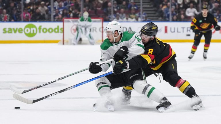 Vancouver Canucks' Conor Garland checks Dallas Stars' Logan Stankoven during the first period of an NHL hockey game in Vancouver, on Thursday, March 28, 2024. (Darryl Dyck/CP Photo)