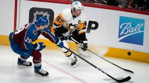 Pittsburgh Penguins centre Sidney Crosby fights for control of the puck with Colorado Avalanche centre Nathan MacKinnon. (David Zalubowski/AP)