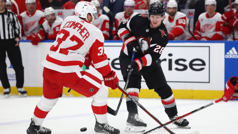 Buffalo Sabres defenceman Rasmus Dahlin (26) passes the puck throught the legs of Detroit Red Wings left wing J.T. Compher (37) during the first period of an NHL hockey game Tuesday, March 12, 2024, in Buffalo, N.Y. (Jeffrey T. Barnes/AP)