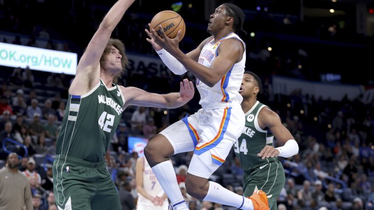 Oklahoma City Thunder forward Jalen Williams (8) goes up for a basket as Milwaukee Bucks center Robin Lopez (42) defends in the first half of a preseason NBA basketball game, Tuesday, Oct. 17, 2023, in Oklahoma City. (AP Photo/Sarah Phipps)
