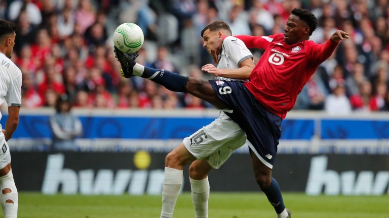 Olimpija's Ahmet Muhamedbegovic and Lille's Jonathan David, right, battle for the ball during the Conference League soccer match between Lille and NK Olimpija Ljubljana, Wednesday, Sept 20, 2023, at the Pierre Mauroy stadium in Villeneuve-d'Ascq, outside Lille northern France. (Michel Spingler/AP)