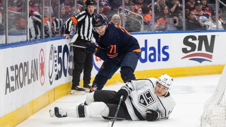 Los Angeles Kings' Trevor Moore (12) and Edmonton Oilers' Ryan McLeod (71) battle for the puck during first period NHL action in Edmonton on Thursday March 28, 2024. (Jason Franson/CP)
