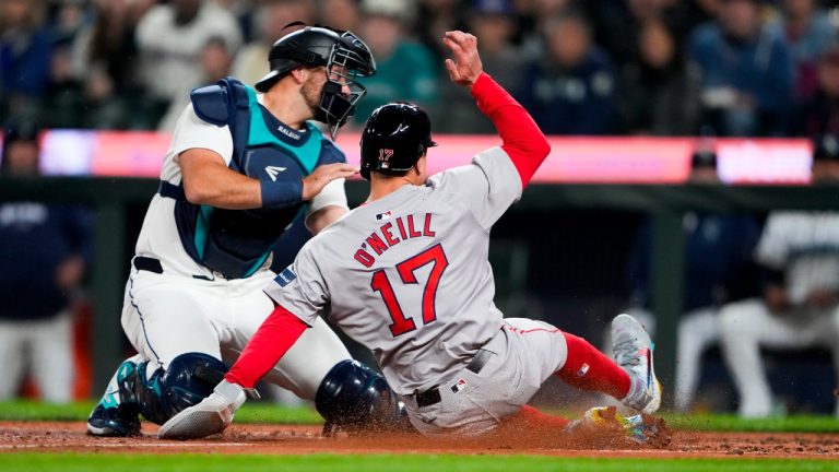 Seattle Mariners catcher Cal Raleigh can't get a tag on Boston Red Sox's Tyler O'Neill, who scored on a throwing error by Mariners third baseman Josh Rojas during the fourth inning of an opening-day baseball game Thursday, March 28, 2024, in Seattle. (Lindsey Wasson/AP)
