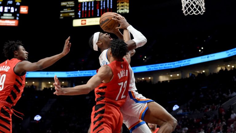 Oklahoma City Thunder guard Shai Gilgeous-Alexander, right, drives to the basket against Portland Trail Blazers guard Rayan Rupert, centre, and guard Ashton Hagans, left, during the first half of an NBA basketball game in Portland, Ore., Wednesday, March 6, 2024. (Steve Dykes/AP Photo)