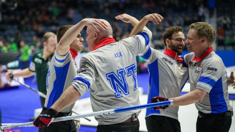 Northwest Territories second Cole Parsons, back from left to right, skip Jamie Koe, lead Shadrach McLeod and third Glen Kennedy celebrate after defeating Prince Edward Island 9-8 in 11 ends to qualify for the playoffs at the Brier, in Regina, on Thursday, March 7, 2024. (Darryl Dyck/CP)