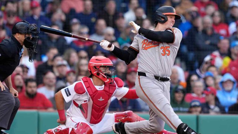 Baltimore Orioles' Adley Rutschman (35) follows-through on his RBI single in front of Boston Red Sox's Reese McGuire during the seventh inning of an opening-day baseball game at Fenway Park, Tuesday, April 9, 2024, in Boston. (Michael Dwyer/AP)