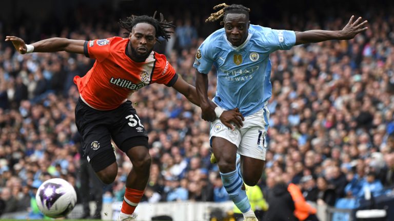 Luton Town's Fred Onyedinma, left, challenges for the ball with Manchester City's Jeremy Doku during the English Premier League soccer match between Manchester City and Luton Town at Etihad stadium in Manchester, England, Saturday, April 13, 2024. (Rui Vieira/AP) 