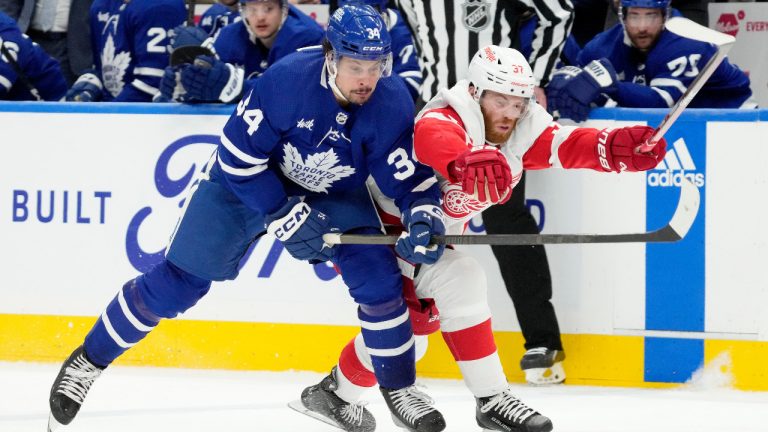 Toronto Maple Leafs centre Auston Matthews (34) and Detroit Red Wings left wing J.T. Compher (37) vie for control of the puck during second period NHL hockey in Toronto, Saturday, April 13, 2024. (Frank Gunn/CP)
