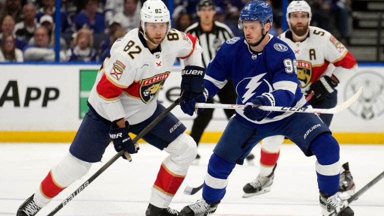 Tampa Bay Lightning defenseman Mikhail Sergachev (98) stops Florida Panthers center Kevin Stenlund (82) during the first period in Game 4 of an NHL hockey Stanley Cup first-round playoff series, Saturday, April 27, 2024, in Tampa, Fla. (AP Photo/Chris O'Meara)