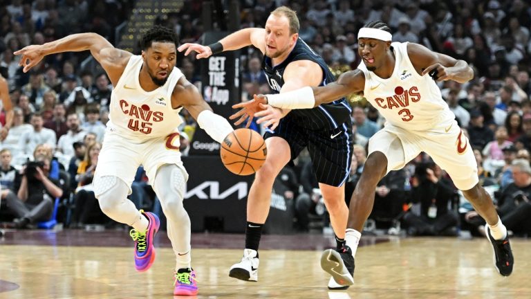 Cleveland Cavaliers' Donovan Mitchell (45) and Caris LeVert (3) steal the ball from Orlando Magic's Joe Ingles during the first half in Game 1 of an NBA basketball first-round playoff series, Saturday, April 20, 2024, in Cleveland. (AP Photo/Nick Cammett)