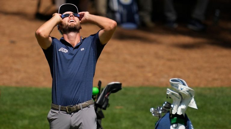 Sam Burns looks up at the sun during a solar eclipse on the 16th hole during a practice round in preparation for the Masters golf tournament at Augusta National Golf Club Monday, April 8, 2024, in Augusta, Ga. (Ashley Landis/AP Photo)