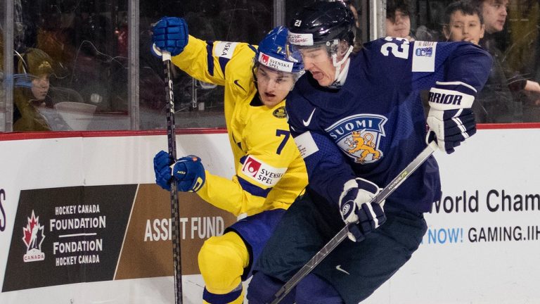 Finland' Kalle Vaisanen (right) battles with Sweden's Calle Odelius during first period IIHF World Junior Hockey Championship quarter-final hockey action in Moncton, N.B., on Monday, January 2, 2023. (Ron Ward/CP)