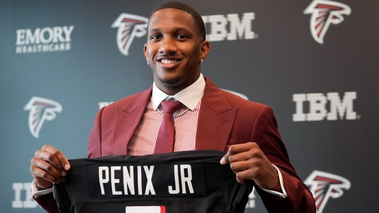 Atlanta Falcons first round draft choice quarterback Michael Penix Jr., holds a Falcons jersey during a news conference Friday, April 26, 2024, in Flowery Branch, Ga. (AP Photo/John Bazemore)