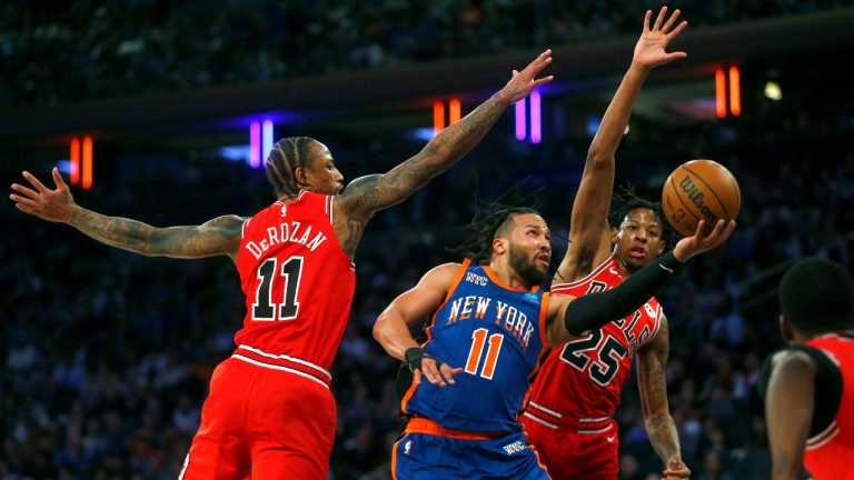 New York Knicks guard Jalen Brunson (11) drives between Chicago Bulls guards DeMar DeRozan (11) and Dalen Terry (25) during the first half of an NBA basketball game Sunday, April 14, 2024, in New York. (AP Photo/John Munson)
