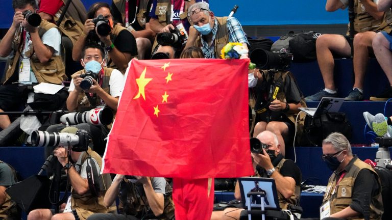 FILE - A Chinese flag is unfurled on the podium of a swimming event final at the 2020 Summer Olympics, on July 29, 2021, in Tokyo, Japan.(Charlie Riedel/AP)