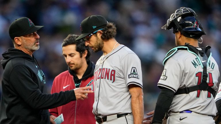 Arizona Diamondbacks manager Torey Lovullo, left, talks with starting pitcher Zac Gallen, who leaves the game with an injury, while catcher Gabriel Moreno, right, watches during the sixth inning of the team's baseball game against the Seattle Mariners, Friday, April 26, 2024, in Seattle. (Lindsey Wasson/AP Photo)