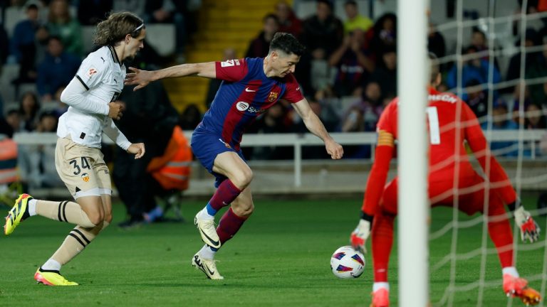 Barcelona's Robert Lewandowski fights for the ball with Valencia's Yarek during a Spanish La Liga soccer match between Barcelona and Valencia at the Olimpic Lluis Companys stadium in Barcelona, Spain, Monday, April 29, 2024. (Joan Monfort/AP)