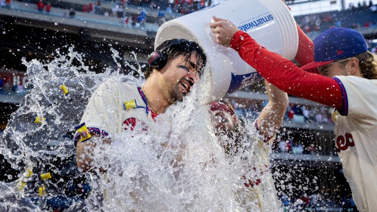 Philadelphia Phillies' Nick Castellanos, left, is doused by teammates Bryson Stott, right, Brandon Marsh, center, after he hit a walkoff single in the ninth inning of a baseball game against the Pittsburgh Pirates, Saturday, April 13, 2024, in Philadelphia. (Laurence Kesterson/AP Photo)