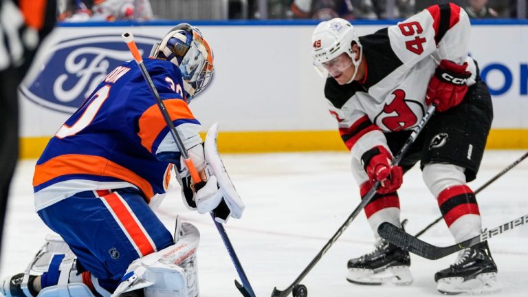 New York Islanders goaltender Ilya Sorokin (30) stops a shot by New Jersey Devils' Ryan Schmelzer (49) during the third period of a preseason NHL hockey game Friday, Oct. 6, 2023, in Elmont, N.Y. (Frank Franklin II/AP)