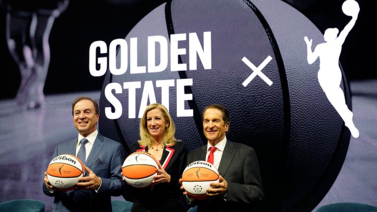 From left, Golden State Warriors CEO Joe Lacob, WNBA Commissioner Cathy Engelbert and Warriors Co-Executive Chairman Peter Guber pose for pictures after an WNBA expansion franchise for the San Francisco Bay Area was announced at Chase Center in San Francisco, Thursday, Oct. 5, 2023. The team will begin play in the 2025 season. (Eric Risberg/AP) 