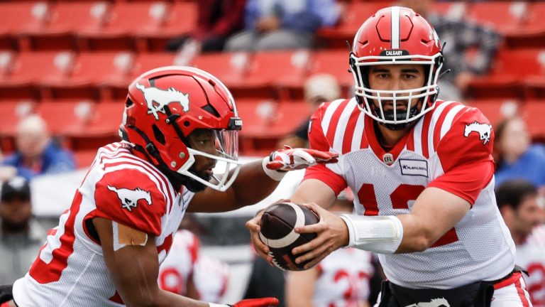 Calgary Stampeders quarterback Jake Maier (12) hands the ball off to running back Peyton Logan (20) against the B.C. Lions during first half CFL preseason football action in Calgary, Saturday, May 25, 2024.THE CANADIAN PRESS/Jeff McIntosh