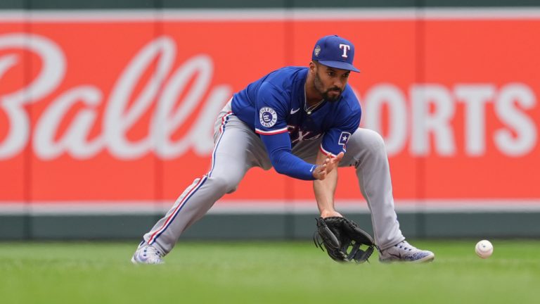 Texas Rangers second baseman Marcus Semien (2) fields a groundout hit by Minnesota Twins' Carlos Santana to force the final out of a baseball game Sunday, May 26, 2024, in Minneapolis. (Abbie Parr/AP)