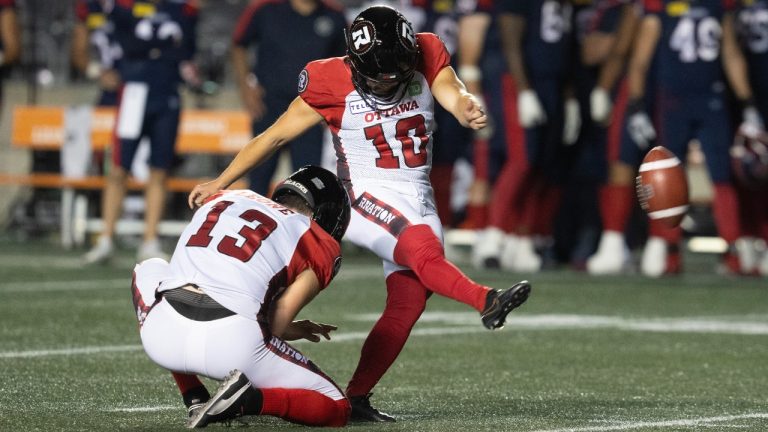 Ottawa RedBlacks kicker Lewis Ward attempts a field goal with Richie Leone (left) during CFL pre-season action against the Montreal Alouettes. (Adrian Wyld/CP)