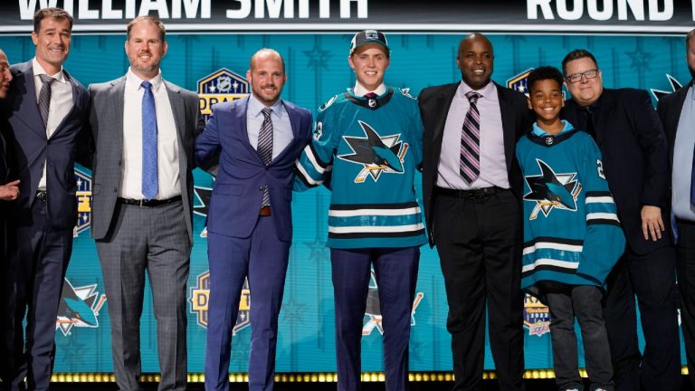 William Smith, center, poses with San Jose Sharks officials after being picked by the team during the first round of the NHL hockey draft Wednesday, June 28, 2023, in Nashville, Tenn. (George Walker IV/AP)