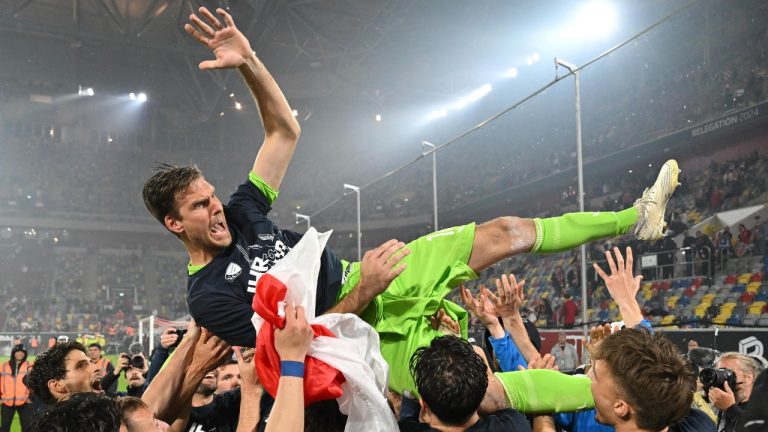 Bochum players celebrate relegation with goalkeeper Andreas Luthe, top, after winning a penalty shootout in a Bundesliga soccer match against Fortuna Duesseldorf, in Duesseldorf, Germany, Monday, May 27, 2024. (Marius Becker/dpa via AP)