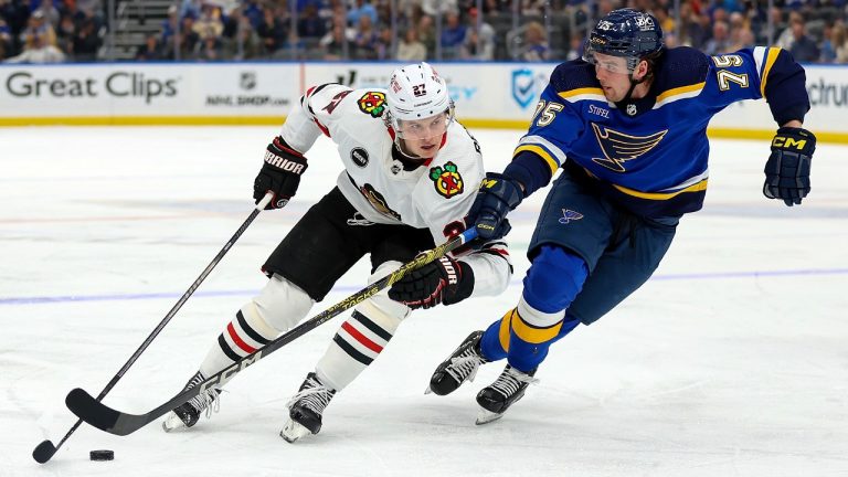 Chicago Blackhawks' Lukas Reichel (27) controls the puck while under pressure from St. Louis Blues' Tyler Tucker (75) during the third period of an NHL hockey game Wednesday, April 10, 2024, in St. Louis. (Scott Kane/AP)