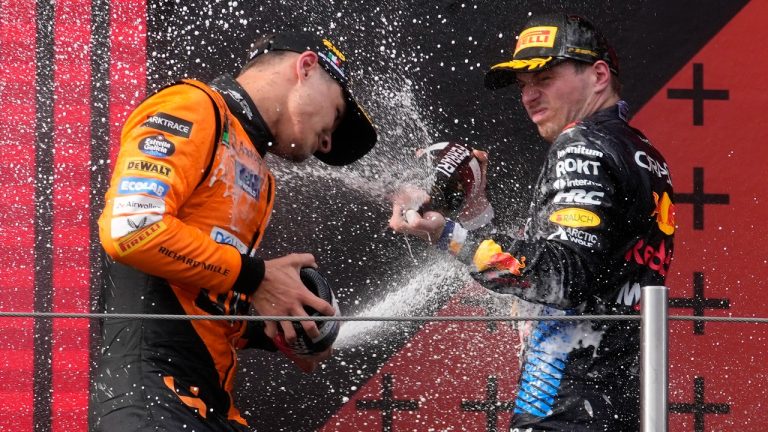 Second-place McLaren driver Lando Norris of Britain, left, celebrates on the podium with winner Red Bull driver Max Verstappen of the Netherlands after the Italy's Emilia Romagna Formula One Grand Prix race at the Dino and Enzo Ferrari racetrack in Imola, Italy, Sunday, May 19, 2024. (Luca Bruno/AP)