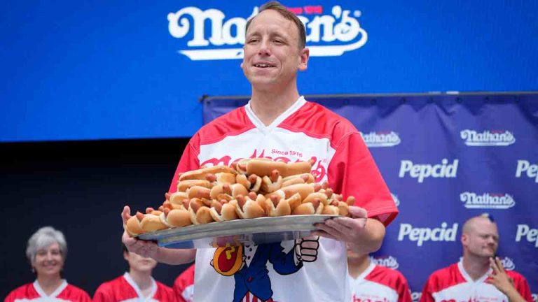 Competitive eater Joey Chestnut holds a plate of hotdogs representing his world record for eating 76 hotdogs and buns in ten minutes during a weigh-in ceremony before the Nathan's Famous July Fourth hot dog eating contest, Monday, July 3, 2023, in New York. (John Minchillo/AP)
