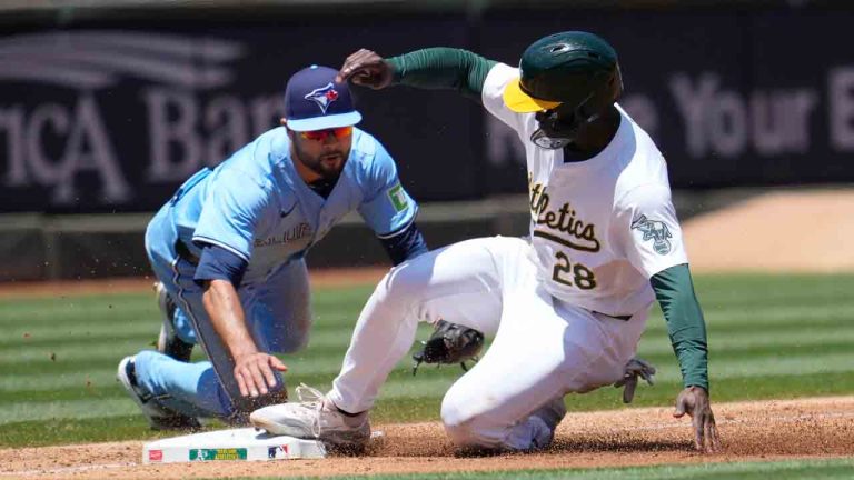 Oakland Athletics' Daz Cameron (28) slides safely into third base in front of Toronto Blue Jays' Isiah Kiner-Falefa during the second inning of a baseball game in Oakland, Calif., Sunday, June 9, 2024. (Jeff Chiu/AP)