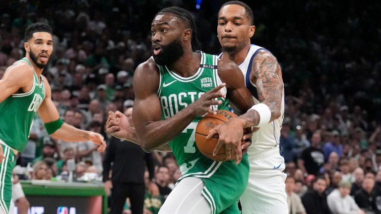 Boston Celtics guard Jaylen Brown, centre, drives toward the basket as Dallas Mavericks forward P.J. Washington, right, defends and Celtics forward Jayson Tatum, left, watches during the first half of Game 5 of the NBA Basketball Finals, Monday, June 17, 2024, in Boston. (Charles Krupa/AP)