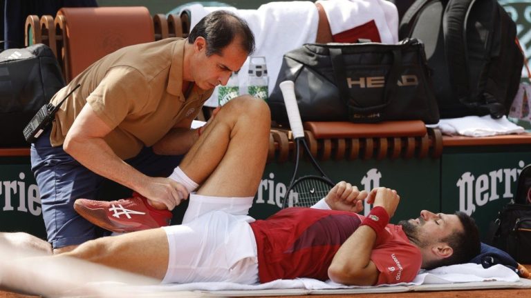 Serbia's Novak Djokovic receives medical assistance for his right knee during his fourth round match of the French Open tennis tournament against Argentina's Francisco Cerundolo at the Roland Garros stadium in Paris, Monday, June 3, 2024. (Jean-Francois Badias/AP Photo)

