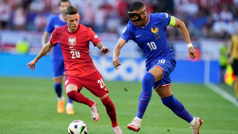 Kylian Mbappe of France passes the ball past Poland's Sebastian Szymanski during a Group D match between France and Poland at the Euro 2024 soccer tournament in Dortmund, Germany, Tuesday, June 25, 2024. (Hassan Ammar/AP Photo)