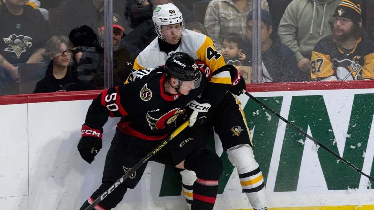 Pittsburgh Penguins right wing Valtteri Puustinen, back, ties up Ottawa Senators defenceman Maxence Guenette along the boards during first period NHL action, Tuesday, March 12, 2024 in Ottawa. (Adrian Wyld/CP)
