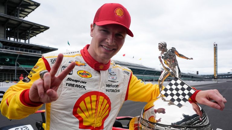 Josef Newgarden poses with the Borg-Warner Trophy during the traditional winners photo session at Indianapolis Motor Speedway. (Darron Cummings/AP)